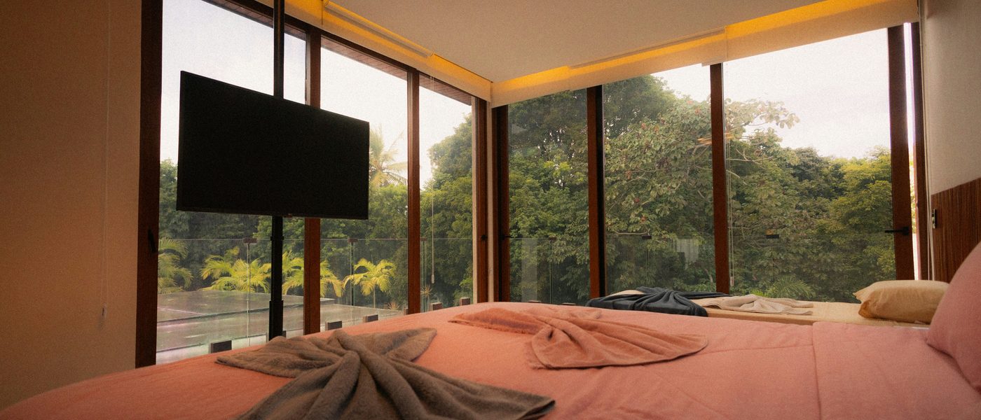 Garden Room with floor-to-ceiling glass wall facing the forest
