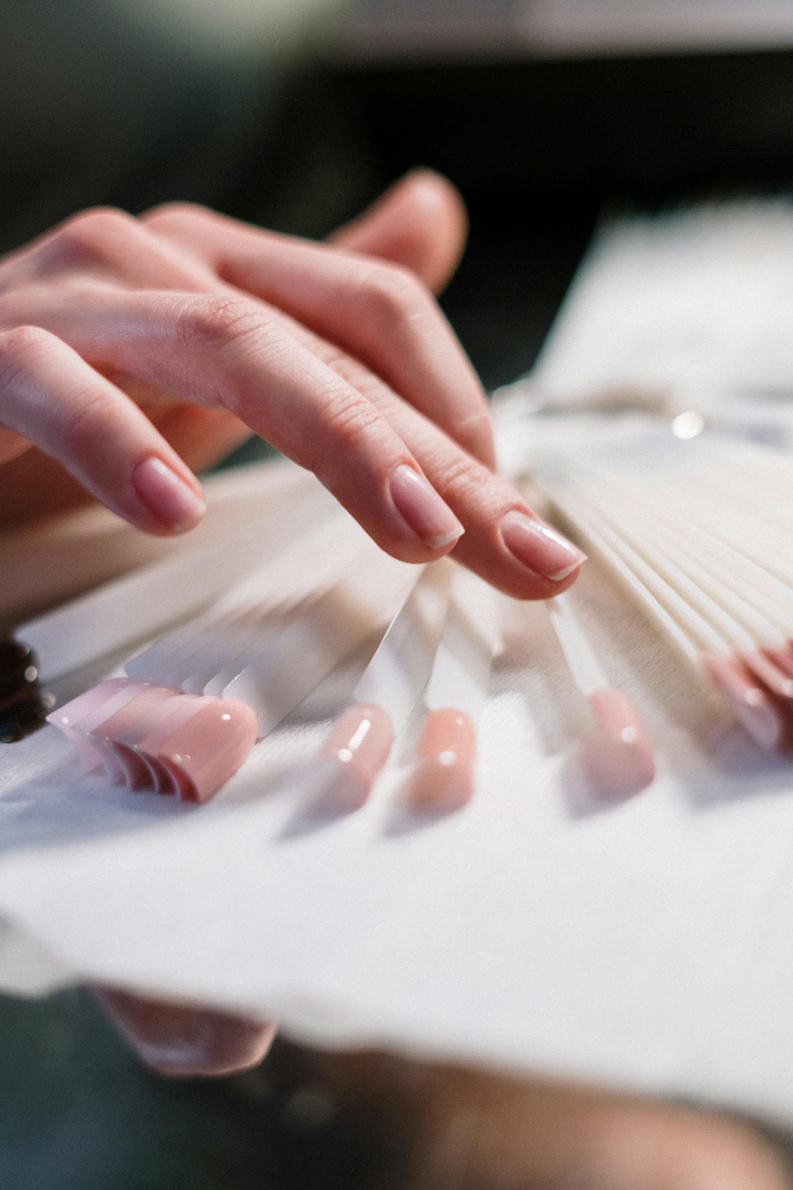 Hand choosing nail color swatches.