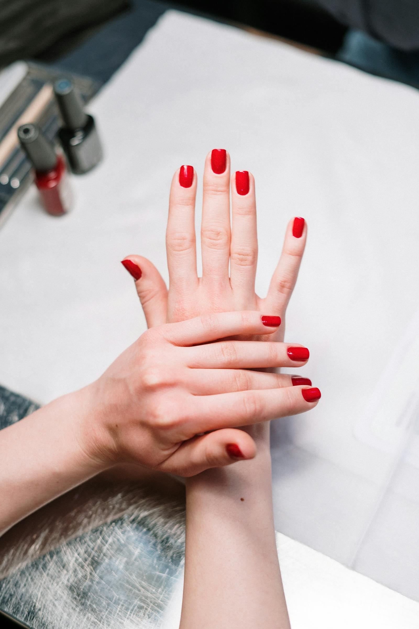 Fresh red nail polish on client hands.